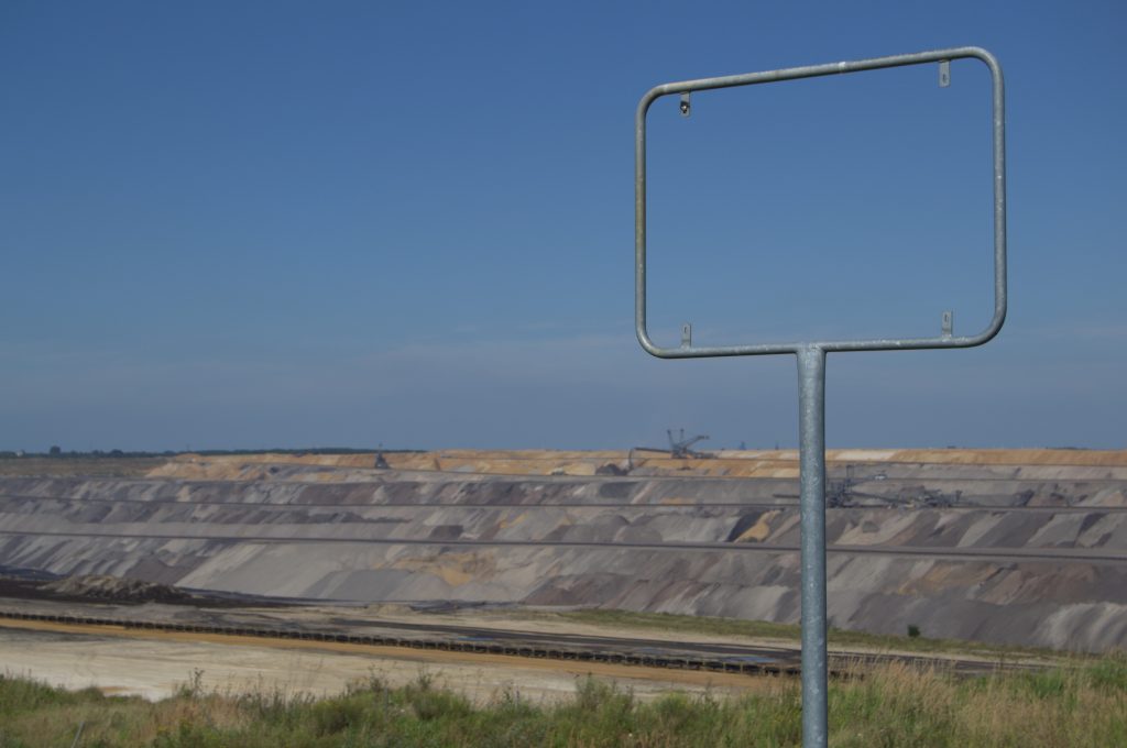 Leeres Ortsschild rahmt den Blick auf den Tagebau Garzweiler (am "Skywalk")